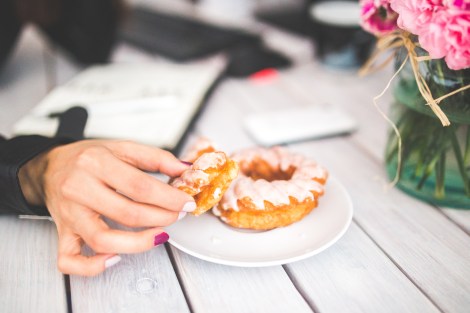 woman reaching for a donut in the office