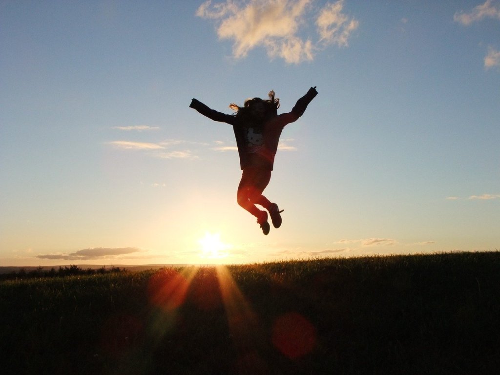person jumping at sunset
